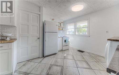 Kitchen featuring butcher block counters, white cabinetry, white appliances, and backsplash - 52 Adam Street, Cambridge, ON - Indoor Photo Showing Kitchen