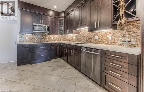 Kitchen with stainless steel appliances, dark brown cabinets, sink, and backsplash - 52 Adam Street, Cambridge, ON - Indoor Photo Showing Kitchen With Upgraded Kitchen