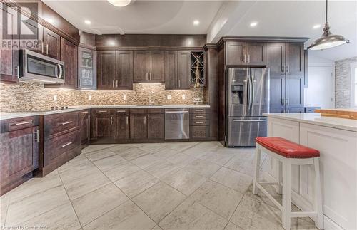 Kitchen featuring stainless steel appliances, dark brown cabinetry, hanging light fixtures, sink, and backsplash - 52 Adam Street, Cambridge, ON - Indoor Photo Showing Kitchen With Upgraded Kitchen