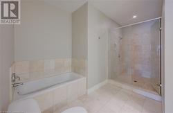 Bathroom featuring toilet, plus walk in shower, and tile patterned floors - 