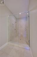 Bathroom featuring tile patterned floors and a shower with door - 