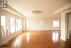 Unfurnished room with a wealth of natural light and wood-type flooring - 