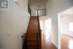 Stairs with hardwood / wood-style floors and a towering ceiling - 