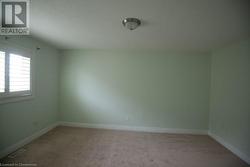 Unfurnished room with a textured ceiling and light colored carpet - 