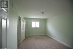 Unfurnished bedroom with light colored carpet and a textured ceiling - 