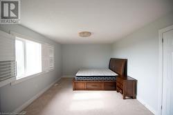 Unfurnished bedroom with light colored carpet and built in desk - 