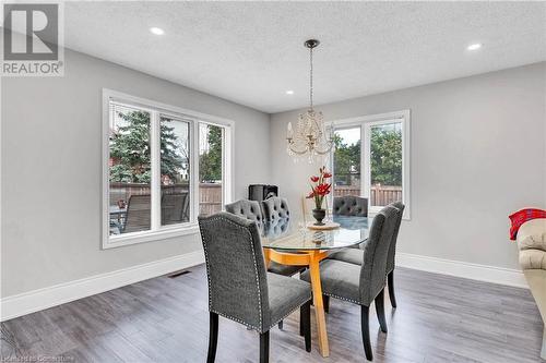 Dining area featuring an inviting chandelier, wood-type flooring, and a textured ceiling - 139 Shady Pine Circle, Brampton, ON - Indoor Photo Showing Dining Room