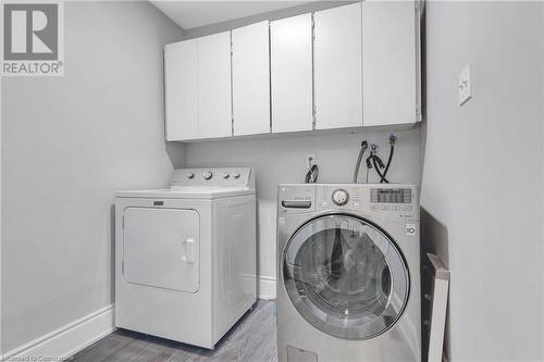 Clothes washing area with light wood-type flooring, cabinets, and separate washer and dryer - 139 Shady Pine Circle, Brampton, ON - Indoor Photo Showing Laundry Room