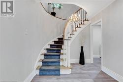 Staircase with an inviting chandelier, hardwood / wood-style floors, and a textured ceiling - 