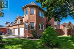 View of side of property with a garage and a lawn - 