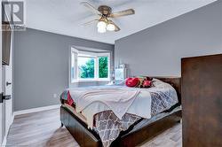 Bedroom featuring a textured ceiling, light wood-type flooring, and ceiling fan - 