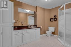 Bathroom featuring walk in shower, vanity, tile patterned floors, and toilet - 