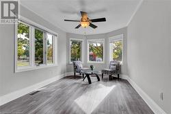 Living area with a textured ceiling, hardwood / wood-style flooring, and ceiling fan - 