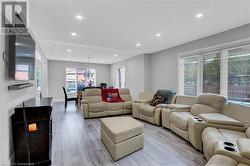 Living room with light wood-type flooring and a chandelier - 