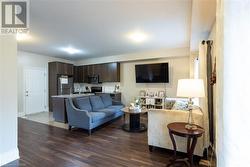 Living room featuring dark wood-type flooring and sink - 