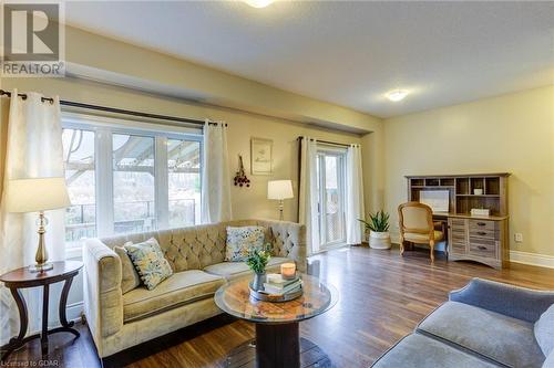 Living room featuring a textured ceiling and dark hardwood / wood-style flooring - 135 Samuel Drive, Arthur, ON 