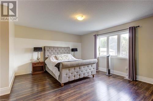 Bedroom featuring dark hardwood / wood-style floors and a textured ceiling - 135 Samuel Drive, Arthur, ON 