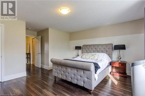 Bedroom featuring dark hardwood / wood-style floors and a textured ceiling - 135 Samuel Drive, Arthur, ON 