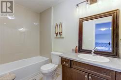 Full bathroom with vanity, tiled shower / bath combo, and toilet - 