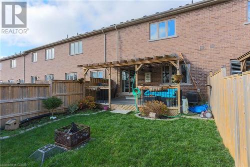 Back of property with a pergola, a lawn, a patio, and an outdoor fire pit - 135 Samuel Drive, Arthur, ON 