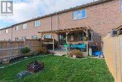 Back of property with a pergola, a lawn, a patio, and an outdoor fire pit - 