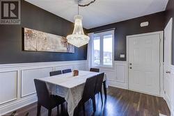 Dining space with dark wood-type flooring and a notable chandelier - 