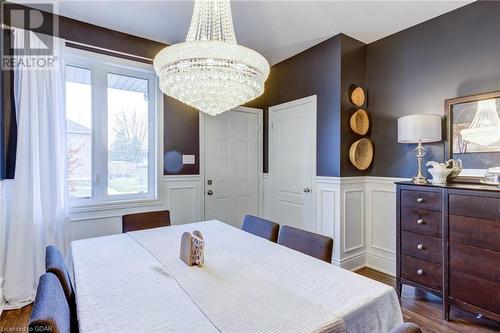 Dining room with a chandelier and dark hardwood / wood-style floors - 135 Samuel Drive, Arthur, ON 