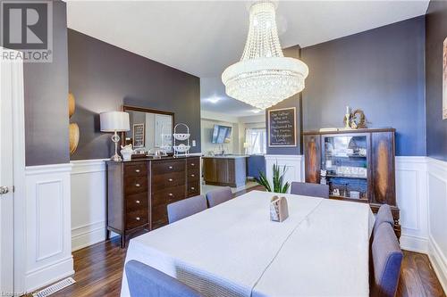 Dining area with dark wood-type flooring and an inviting chandelier - 135 Samuel Drive, Arthur, ON 