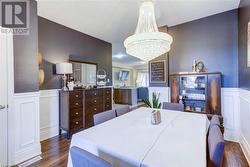 Dining area with dark wood-type flooring and an inviting chandelier - 