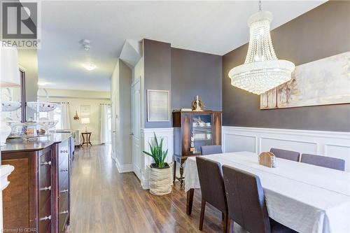 Dining space featuring a chandelier and dark wood-type flooring - 135 Samuel Drive, Arthur, ON 