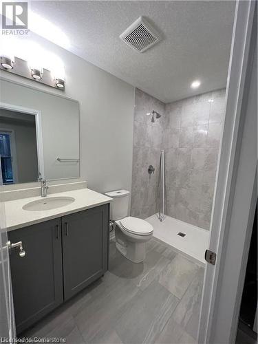 Bathroom with vanity, a textured ceiling, toilet, and tiled shower - 25 Isherwood Avenue Unit# 42, Cambridge, ON 