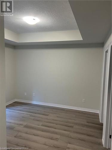 Spare room featuring wood-type flooring and a textured ceiling - 25 Isherwood Avenue Unit# 42, Cambridge, ON 