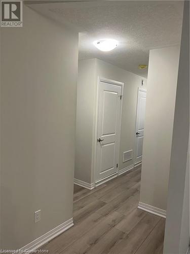 Corridor featuring hardwood / wood-style floors and a textured ceiling - 25 Isherwood Avenue Unit# 42, Cambridge, ON 