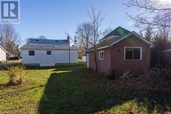 Back of house with an outdoor structure and a yard - 