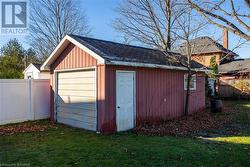 View of outdoor structure featuring a garage and a lawn - 