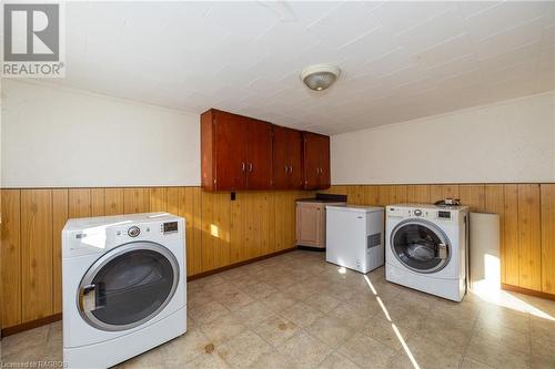 Laundry area featuring wood walls, cabinets, and independent washer and dryer - 1710 7Th Avenue E, Owen Sound, ON - Indoor Photo Showing Laundry Room