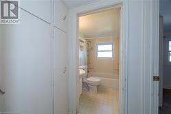 Bathroom with toilet and bathing tub / shower combination - 