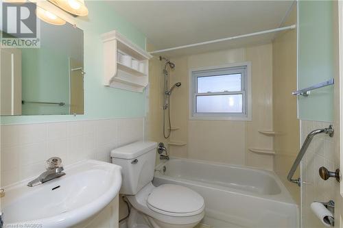 Full bathroom with sink, tiled shower / bath combo, tile walls, and toilet - 1710 7Th Avenue E, Owen Sound, ON - Indoor Photo Showing Bathroom