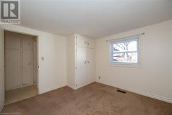 Unfurnished bedroom featuring light carpet - 