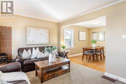 Living room with light wood-type flooring and crown molding - 