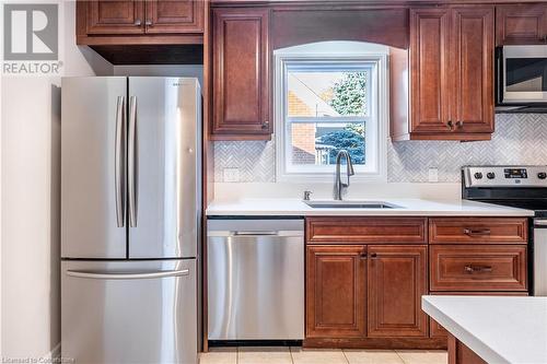 Kitchen featuring stainless steel appliances, light tile patterned flooring, sink, and tasteful backsplash - 645 Weber Street E, Kitchener, ON - Indoor Photo Showing Kitchen With Stainless Steel Kitchen