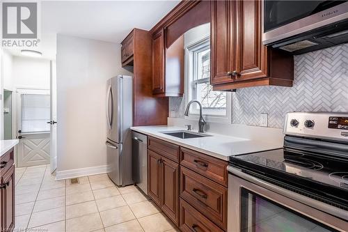 Kitchen featuring light tile patterned floors, sink, appliances with stainless steel finishes, and tasteful backsplash - 645 Weber Street E, Kitchener, ON - Indoor Photo Showing Kitchen With Stainless Steel Kitchen