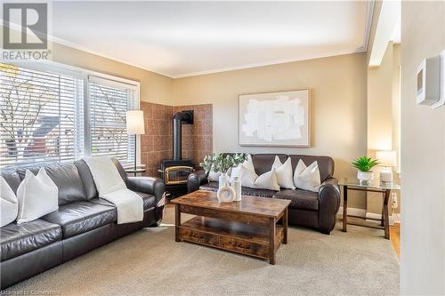 Living room featuring a wood stove, light carpet, and crown molding - 645 Weber Street E, Kitchener, ON - Indoor Photo Showing Living Room