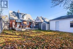 Rear view of house featuring a storage shed, a wooden deck, and a yard - 