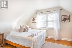 Bedroom featuring light hardwood / wood-style flooring and vaulted ceiling - 