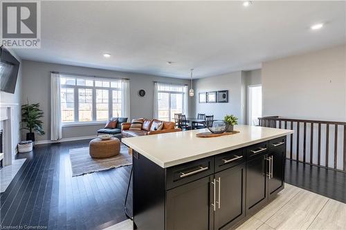 Kitchen with pendant lighting, light hardwood / wood-style floors, and a center island - 219 Falconridge Drive, Waterloo, ON - Indoor Photo Showing Living Room With Fireplace