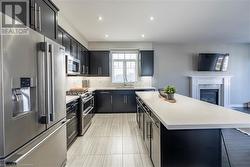 Kitchen with a center island, light tile patterned floors, tasteful backsplash, sink, and high quality appliances - 