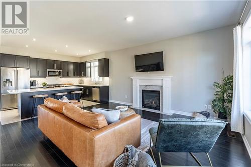 Living room featuring a fireplace, dark hardwood / wood-style floors, and sink - 219 Falconridge Drive, Waterloo, ON - Indoor With Fireplace