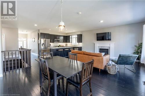 Dining space with a chandelier and dark hardwood / wood-style flooring - 219 Falconridge Drive, Waterloo, ON - Indoor Photo Showing Dining Room With Fireplace