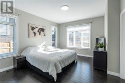 Bedroom featuring dark hardwood / wood-style flooring and multiple windows - 